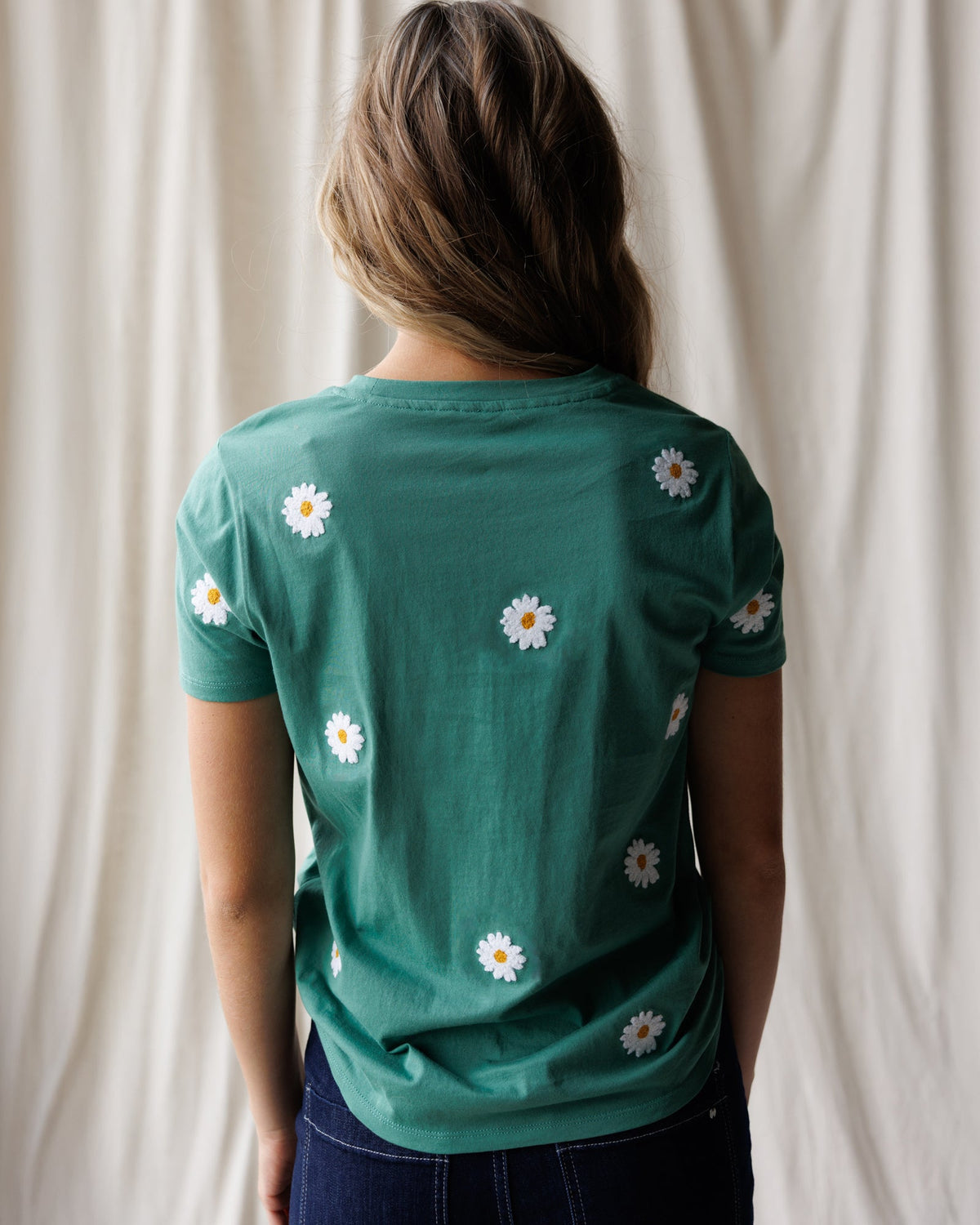 Women's teal back of tee with scattered white daisy embroidery, crew neck.