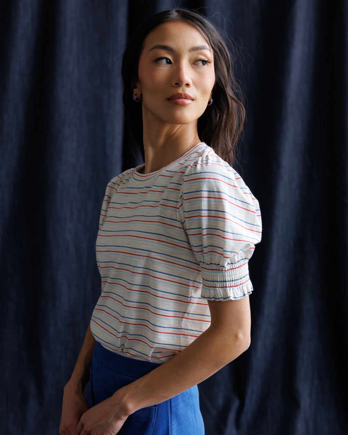Women’s striped puff-sleeve top viewed from the side, with crew neck