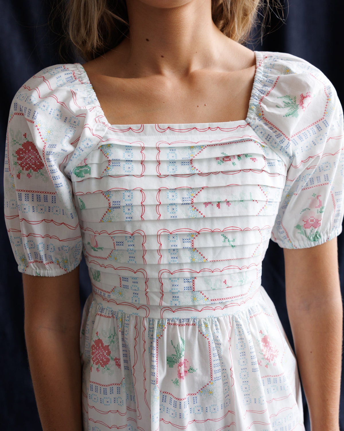 Square neckline dress with ruffled trim, cross-stitch style pattern, short puff sleeves