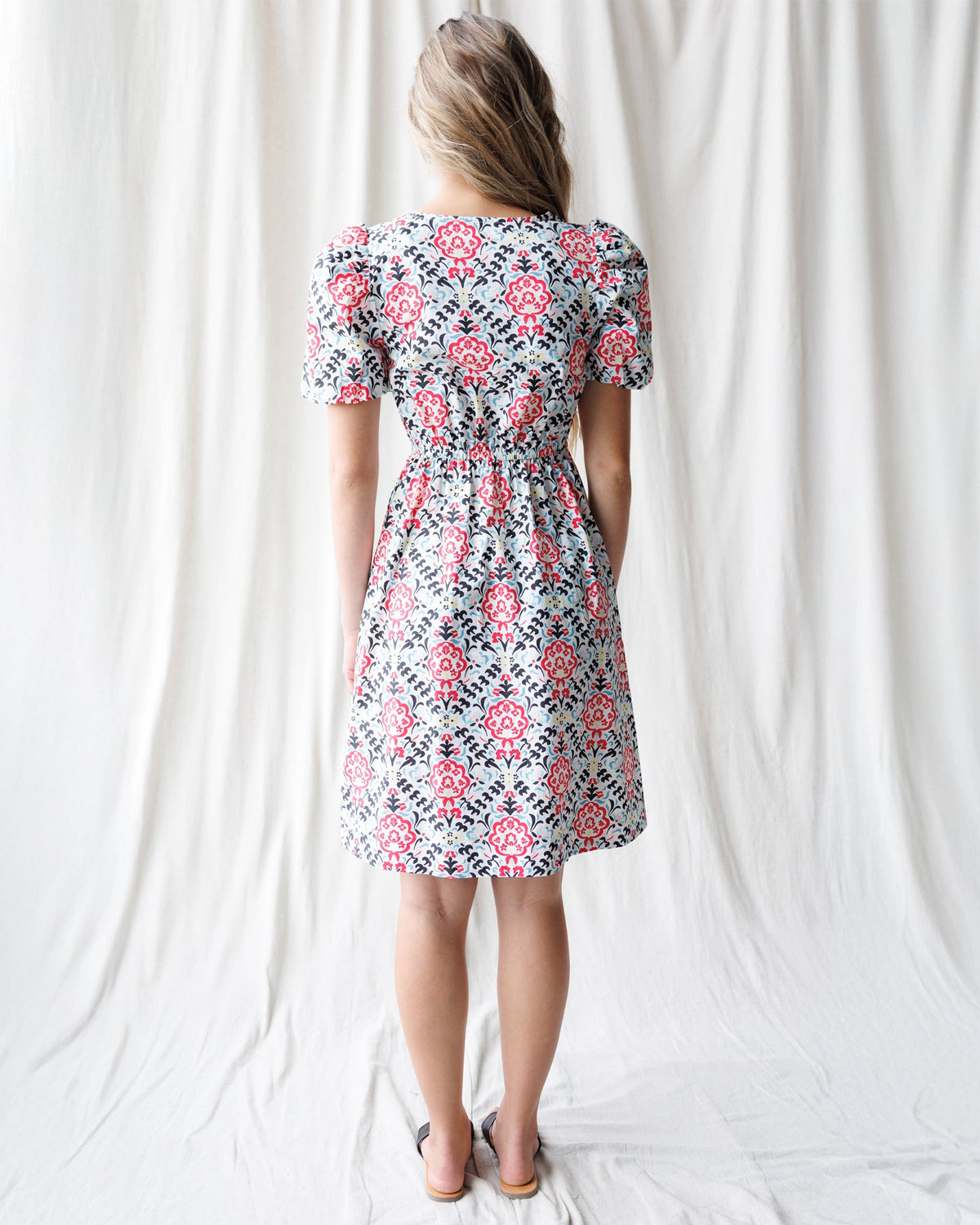 Capri dress back view, red and blue floral print, short sleeves, gathered waist