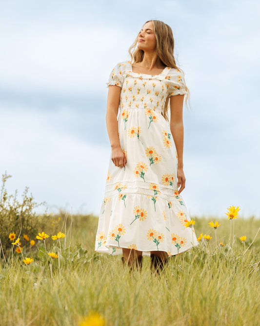 White tiered midi dress with puff sleeves and yellow-orange floral print