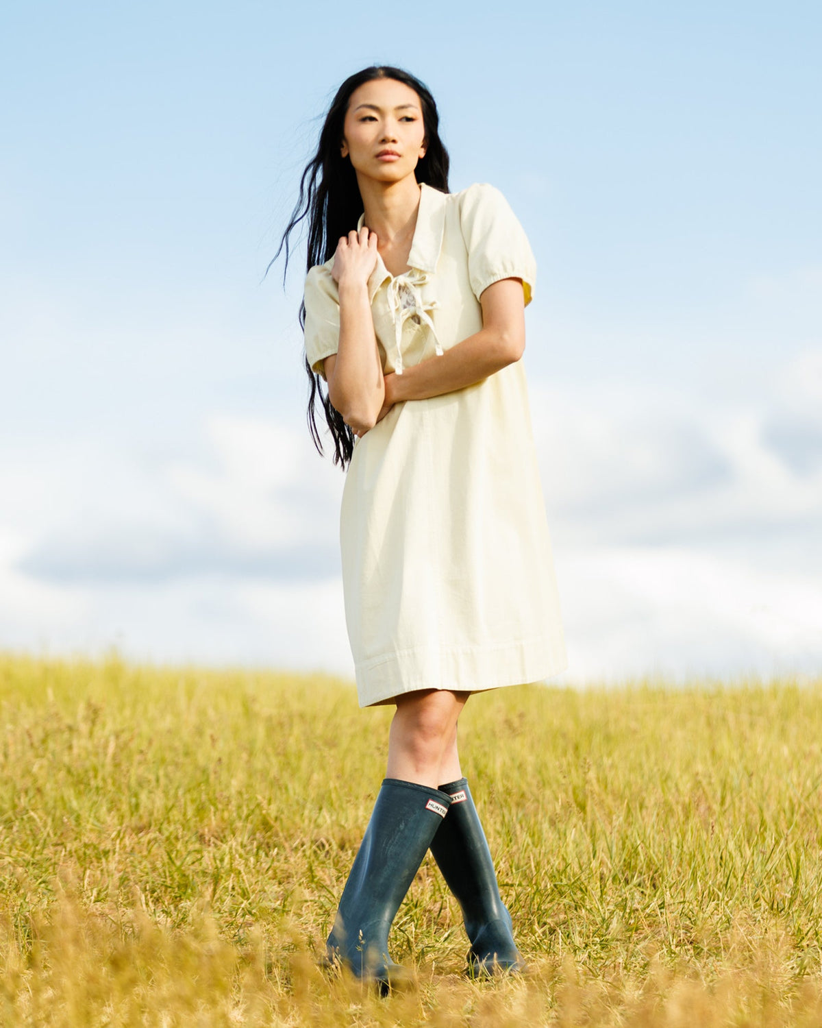 Light yellow denim dress with collared neckline and ribbon bow, short puff sleeves