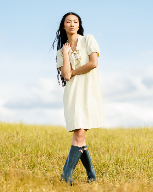 Light yellow denim dress with collared neckline and ribbon bow, short puff sleeves