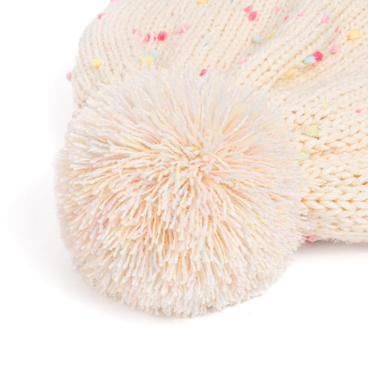 Close-up of fluffy pom-pom on a pale speckled knit beanie