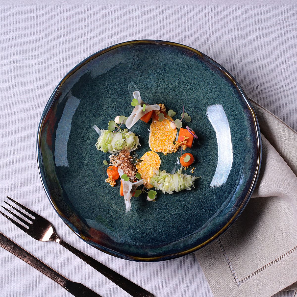 Reactive glazed pasta plate with plated food, glossy dark teal-green finish