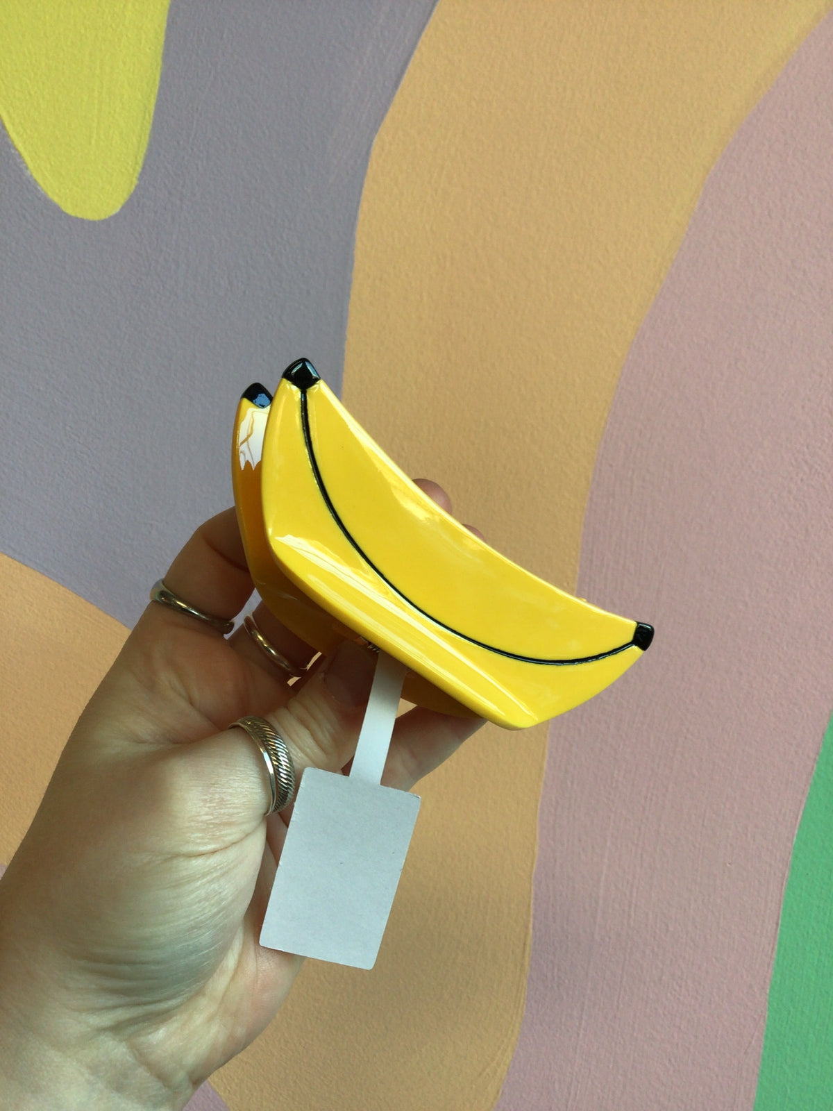 Banana-shaped hair claw in bright yellow with small black tip details