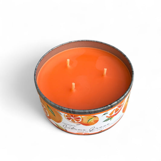 Top view of lit citrus soy candle in round tin with three flames