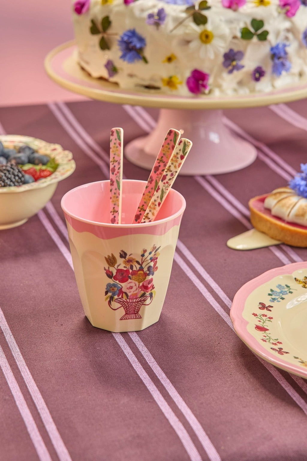 Pink melamine cup with floral basket print and two decorated paper straws
