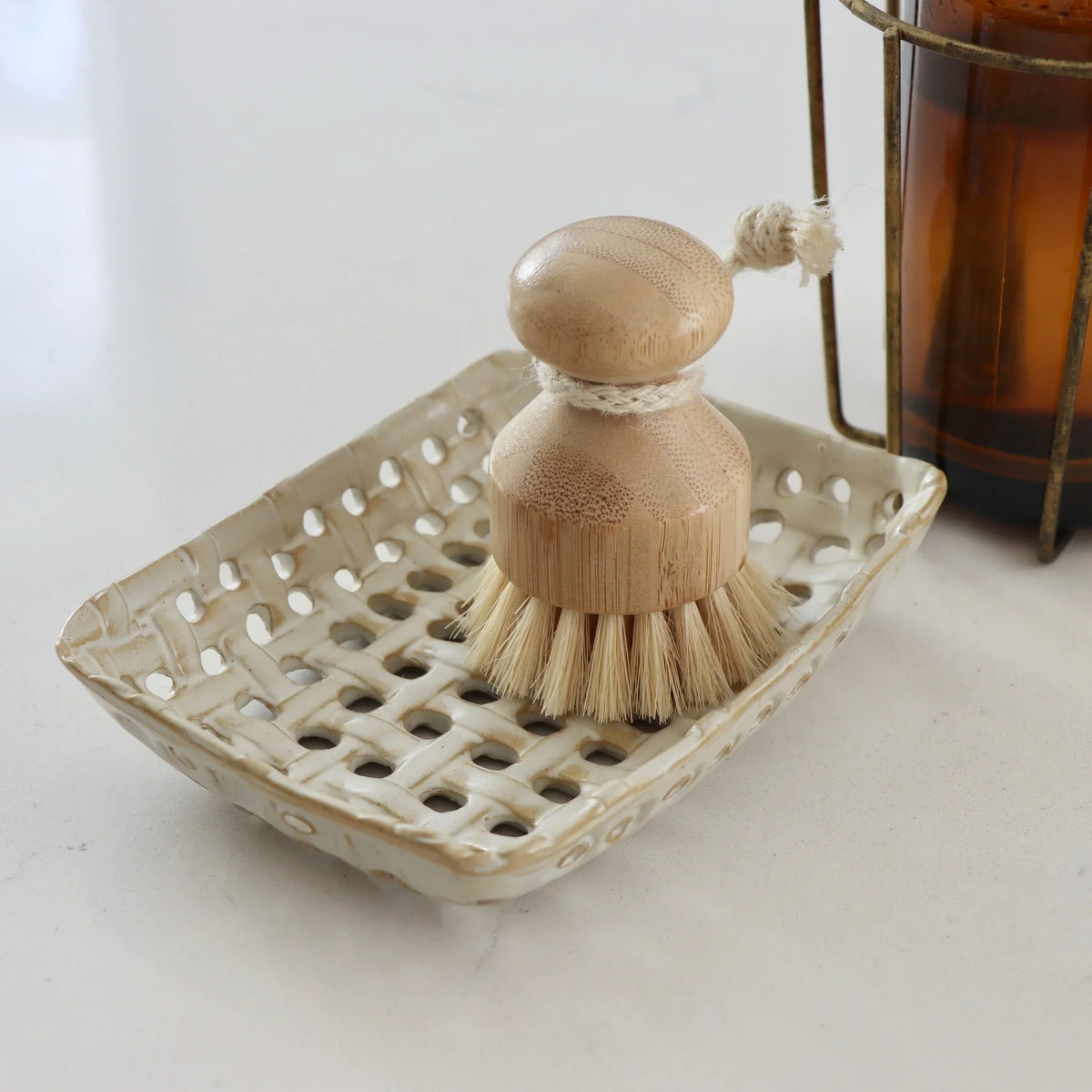 Cream glazed ceramic lattice basket dish with a brush and bristles
