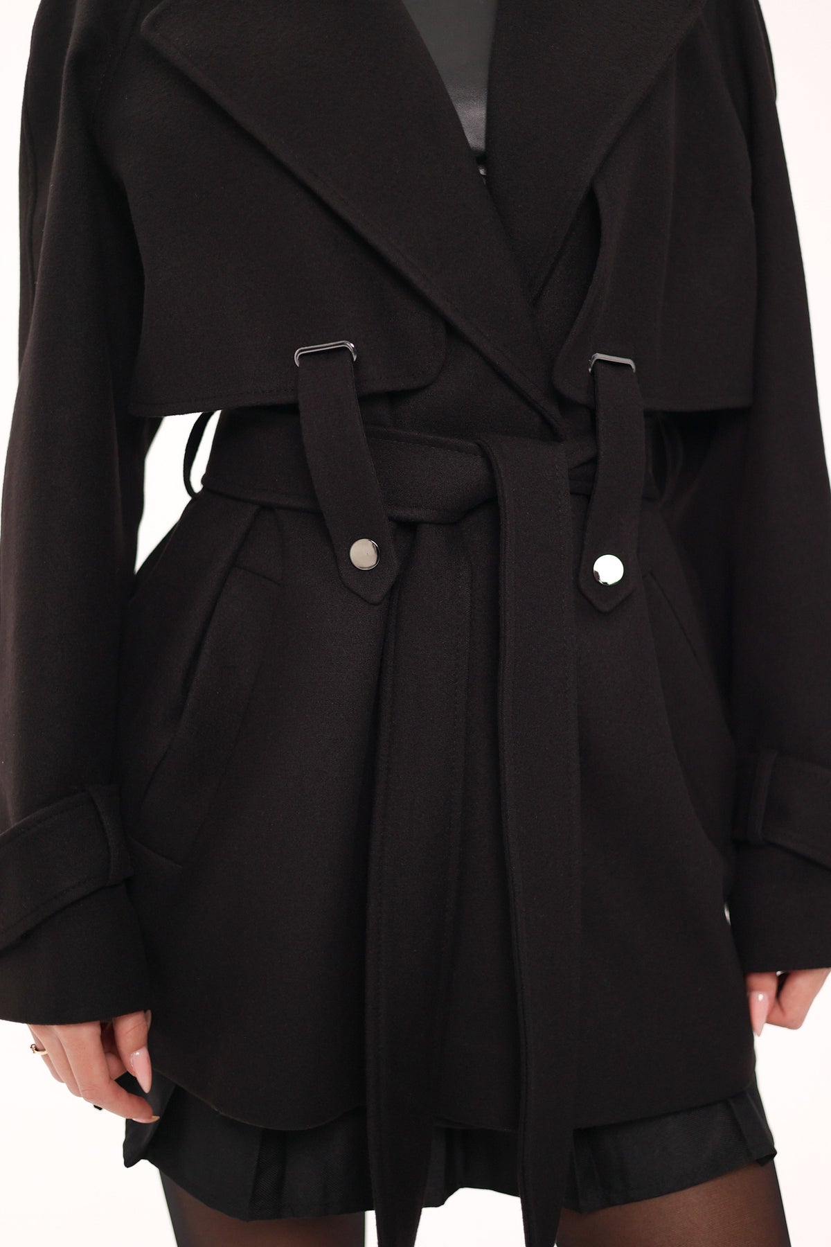 Close-up of the coat's wide lapels, belt loops, buckle tabs, and tie belt.