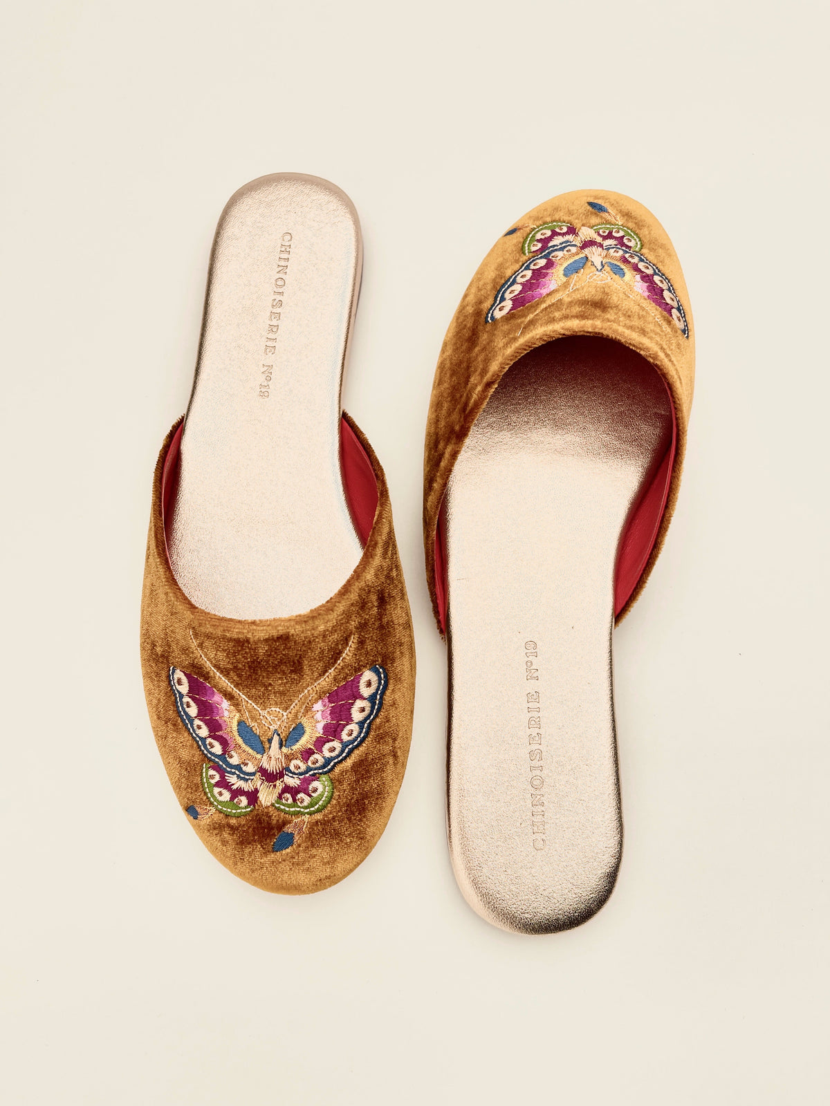 Antique gold velvet mules showing open top and butterfly embroidery