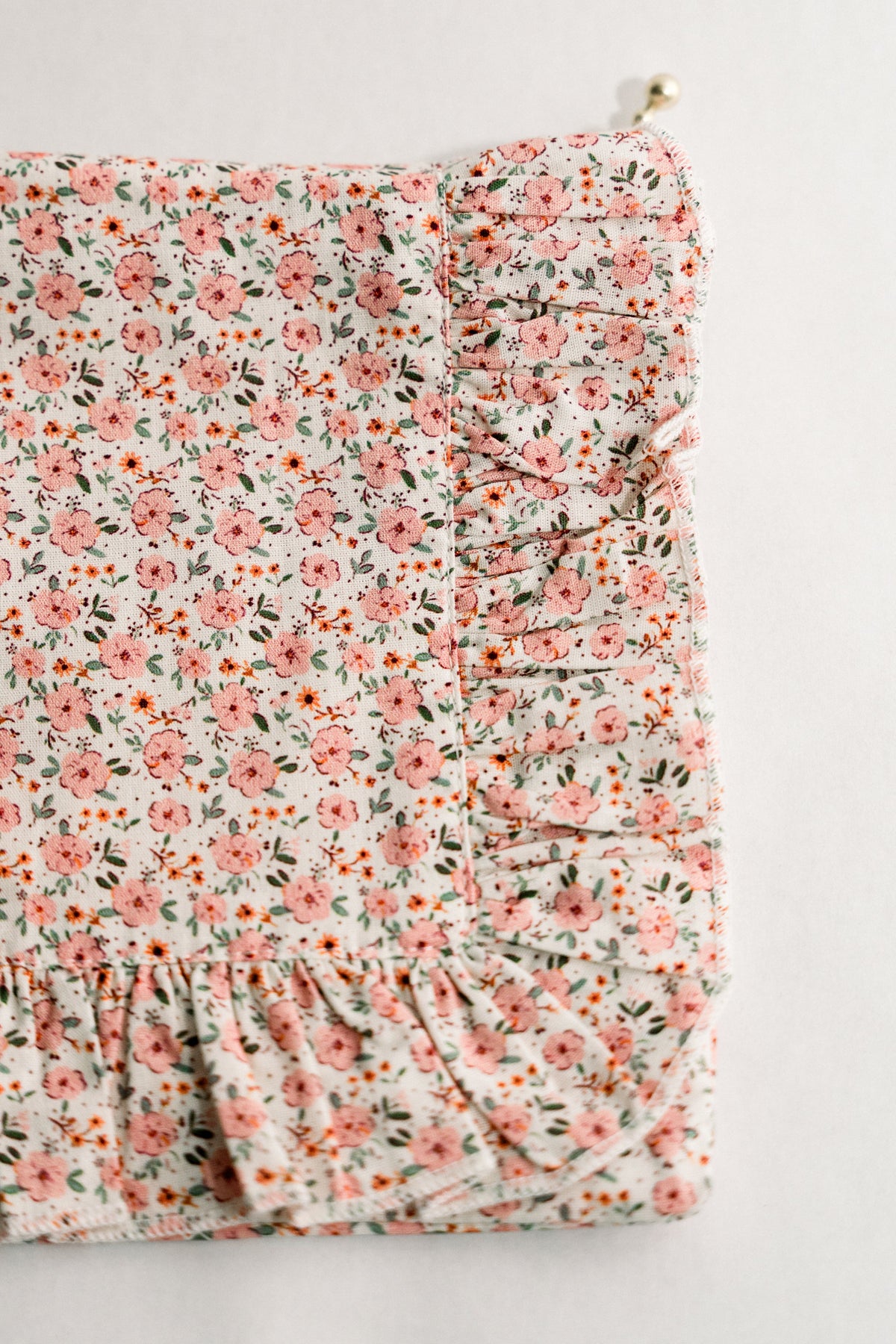 Peach floral ruffle zipper pouch, side gathered detail and gold zipper pull