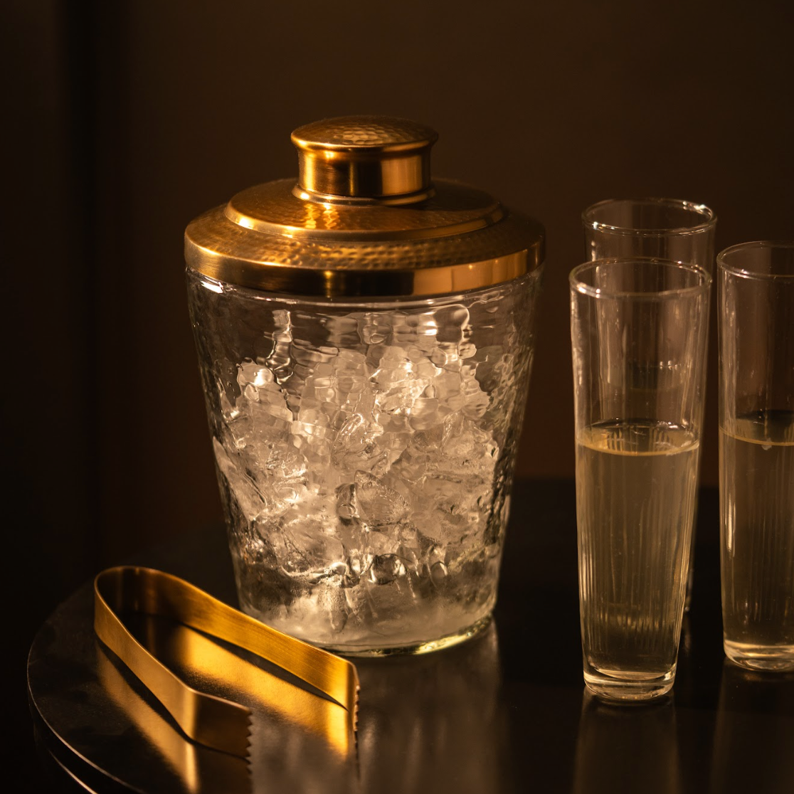 Gold-tone pebbled ice bucket with lid, gold tongs, and two clear tumblers