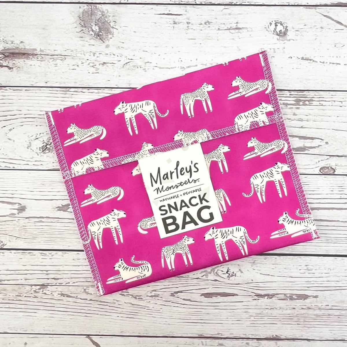 Reusable snack bag with bright pink and white animal print, sealed top closure flap.
