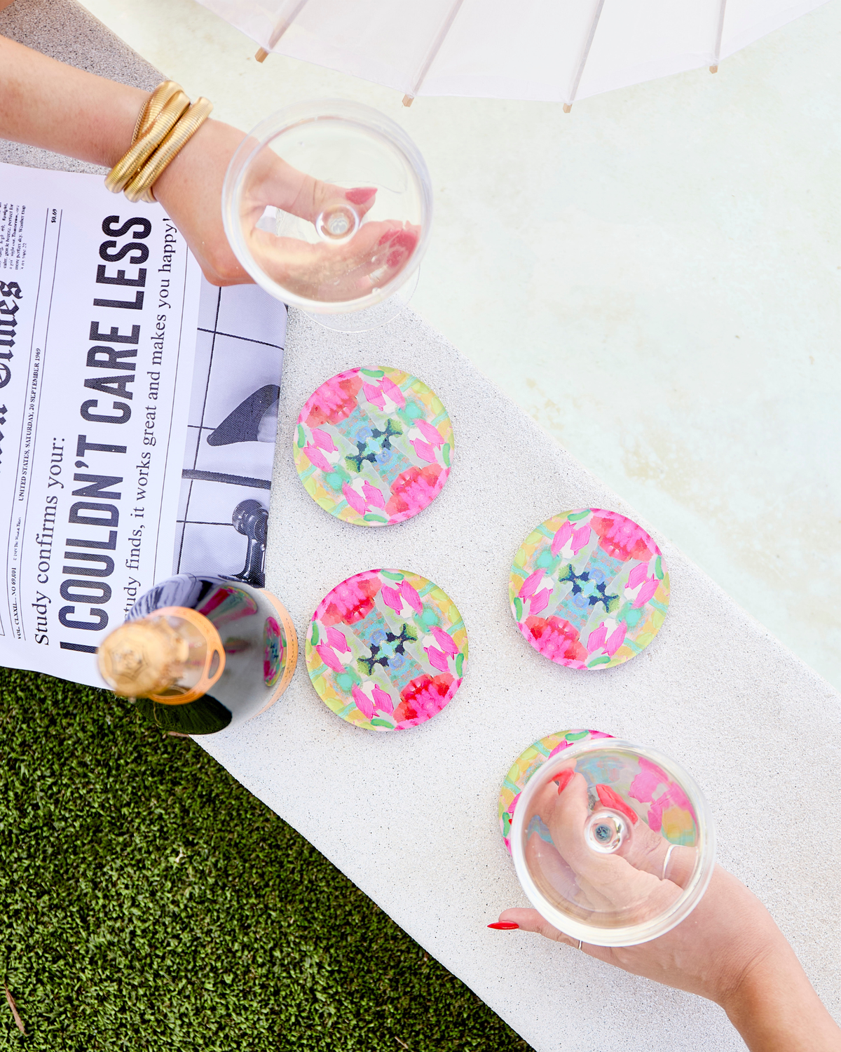 Set of round acrylic drink coasters with pink, green, and blue floral confetti design