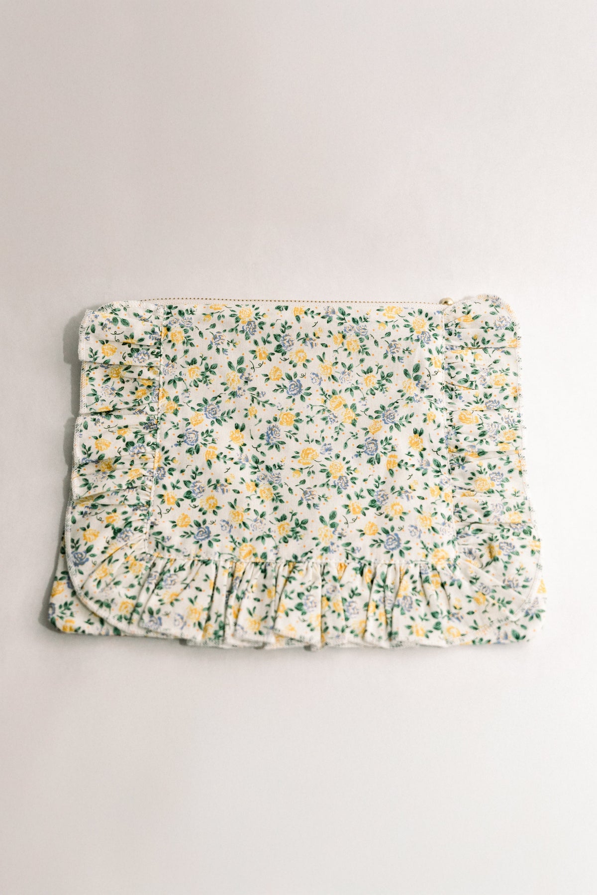 Floral ruffle zipper pouch with gathered bottom, cream fabric and multicolor flowers.