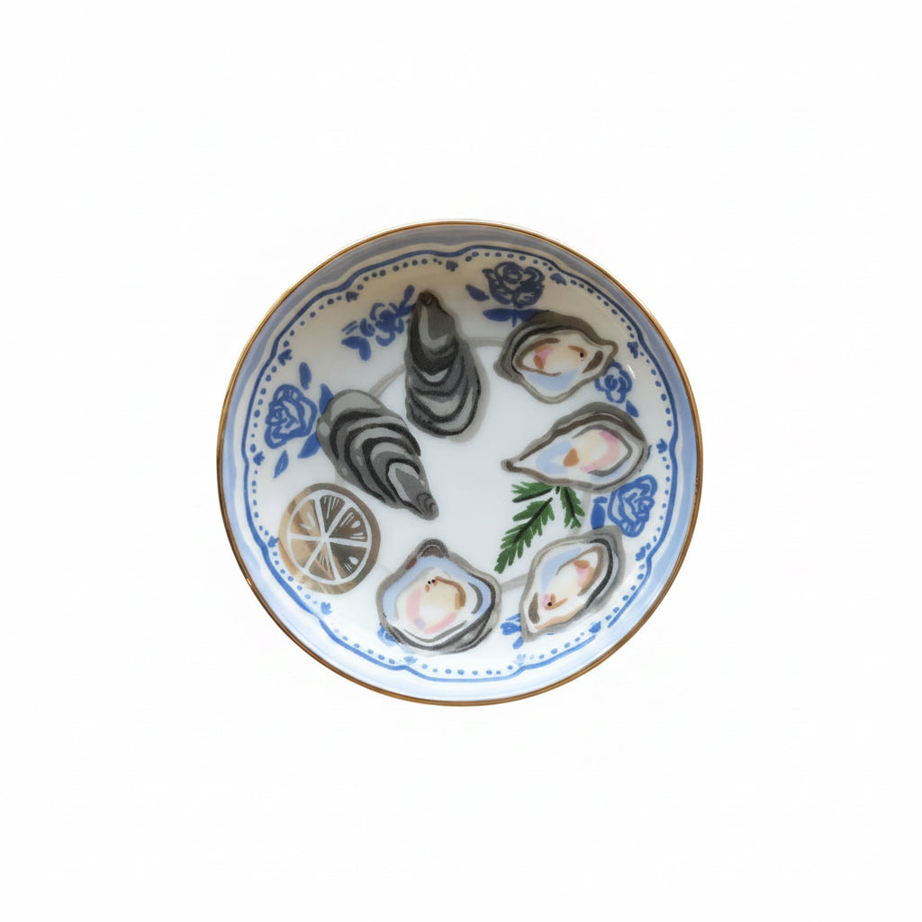 Round porcelain dice dish with oyster-shell and lemon seafood illustrations, blue trim