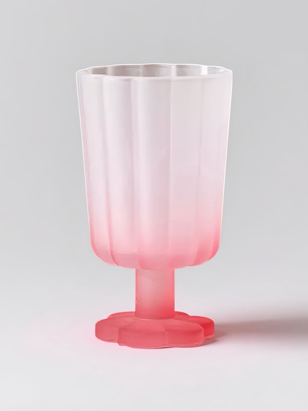 Hand-blown petal wine goblet with pink ombre body and red foot.