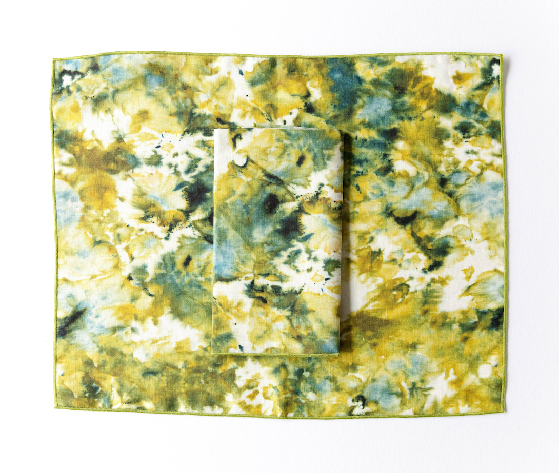 Gold-trimmed marble placemat set in green and yellow, square with visible layered stack