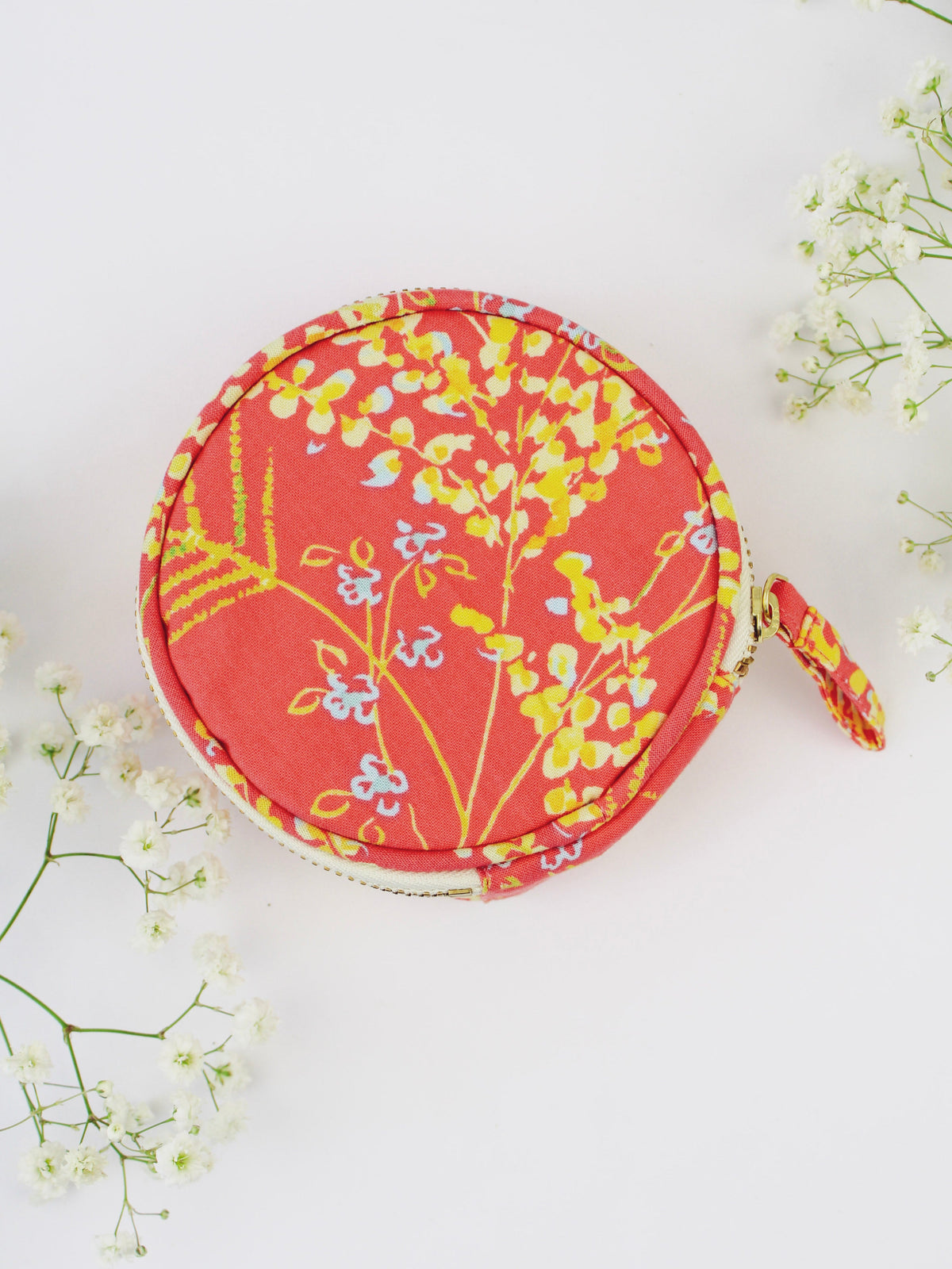 Round coral floral jewelry pouch with gold-tone zipper and dangling wrist strap