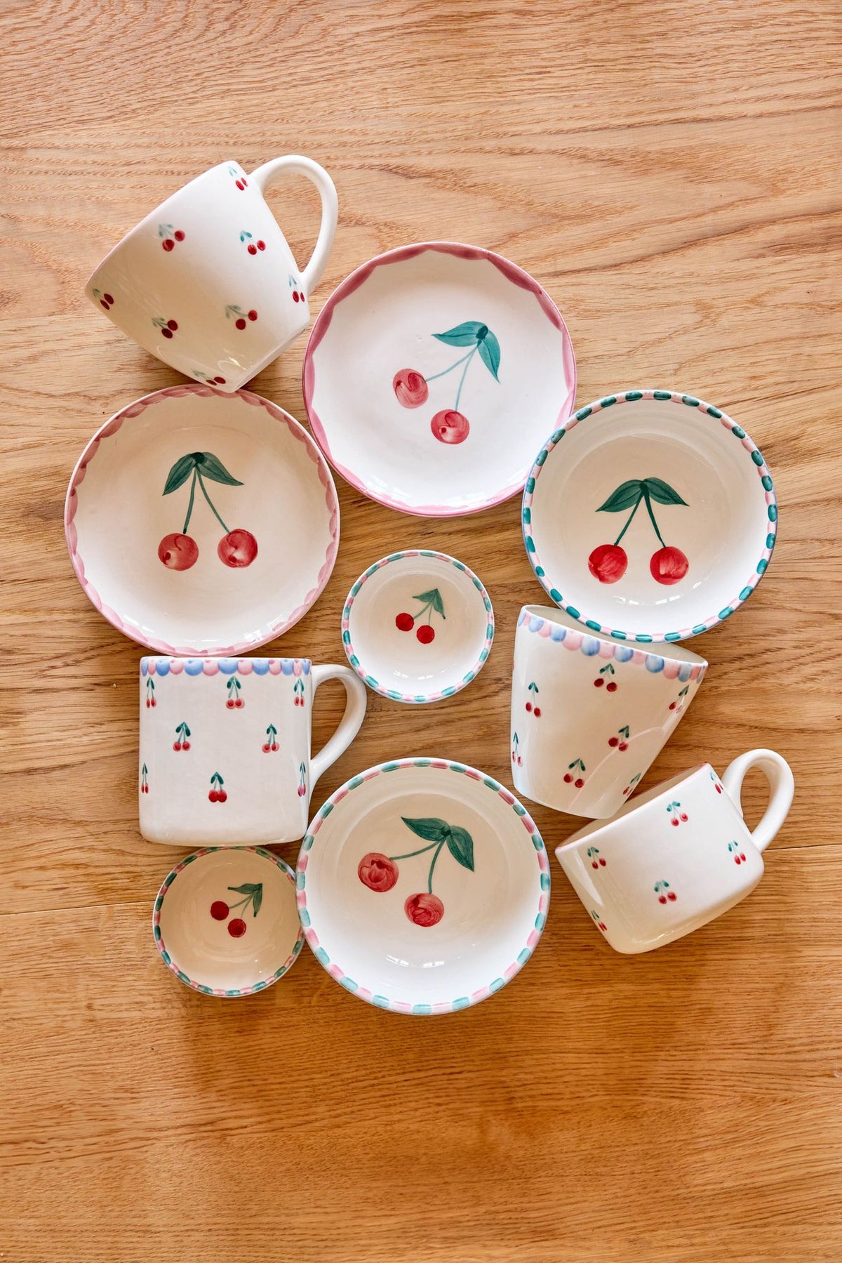 Set of ceramic cups and saucers with hand-painted cherry and leaf pattern