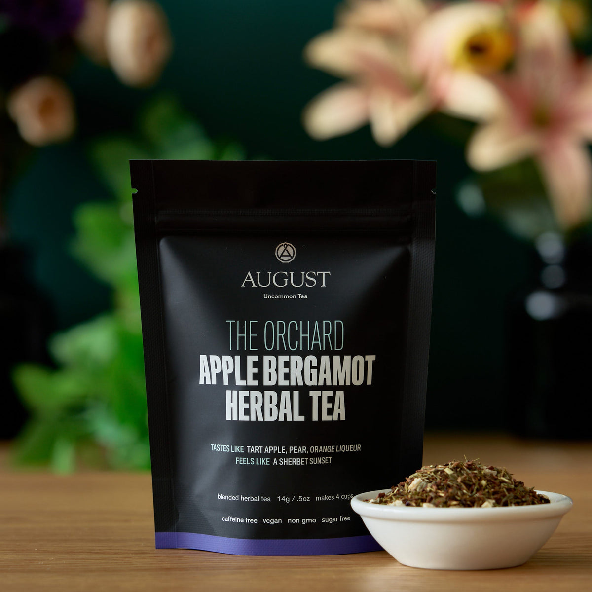 The Orchard apple bergamot herbal tea pouch and loose tea in a bowl