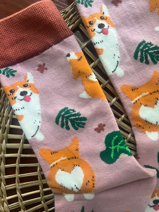 Corgi socks with pink cuff, light lavender fabric, orange dogs and green leaf pattern