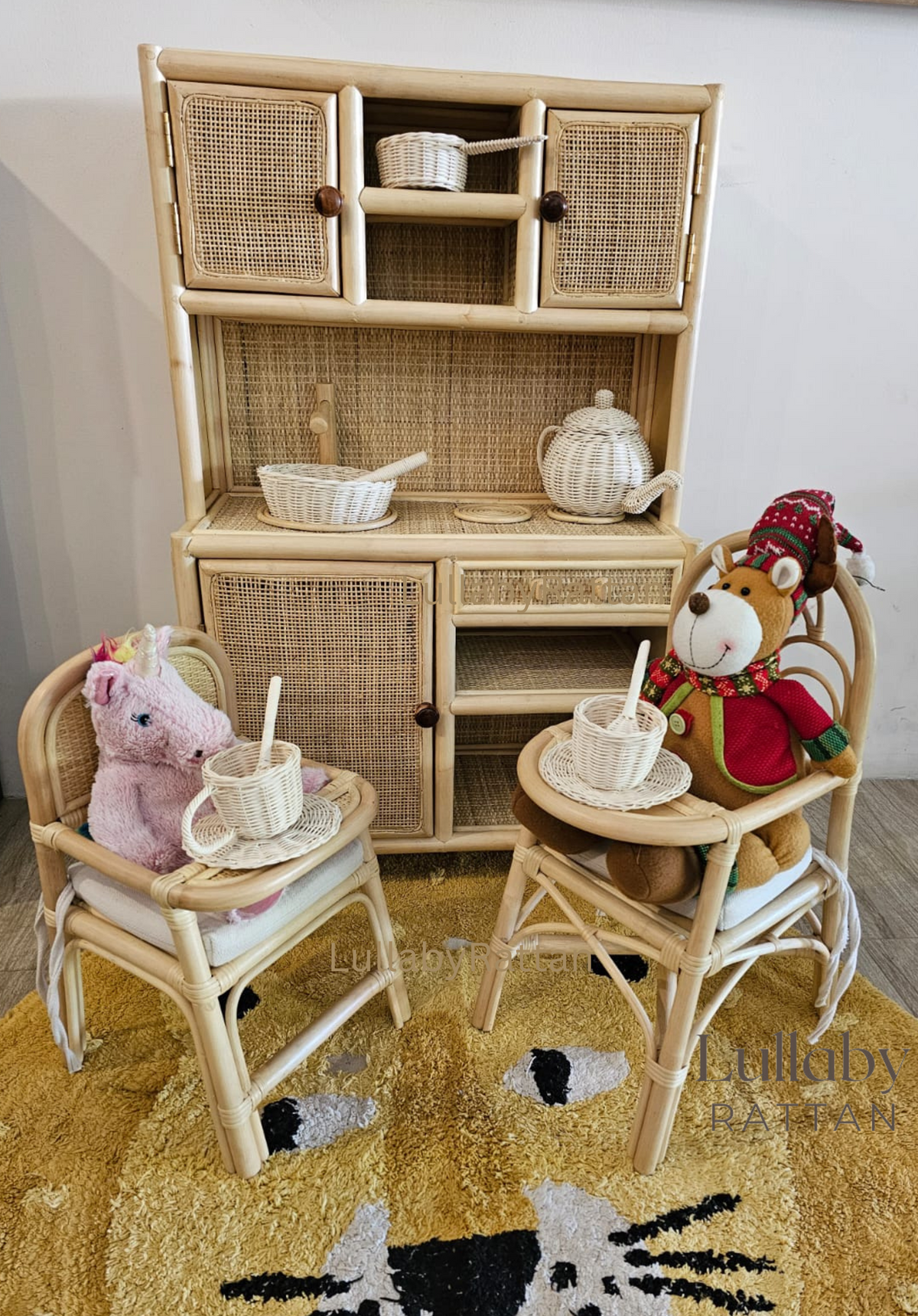 Rattan doll high chair beside a toy cabinet, holding a plush bunny