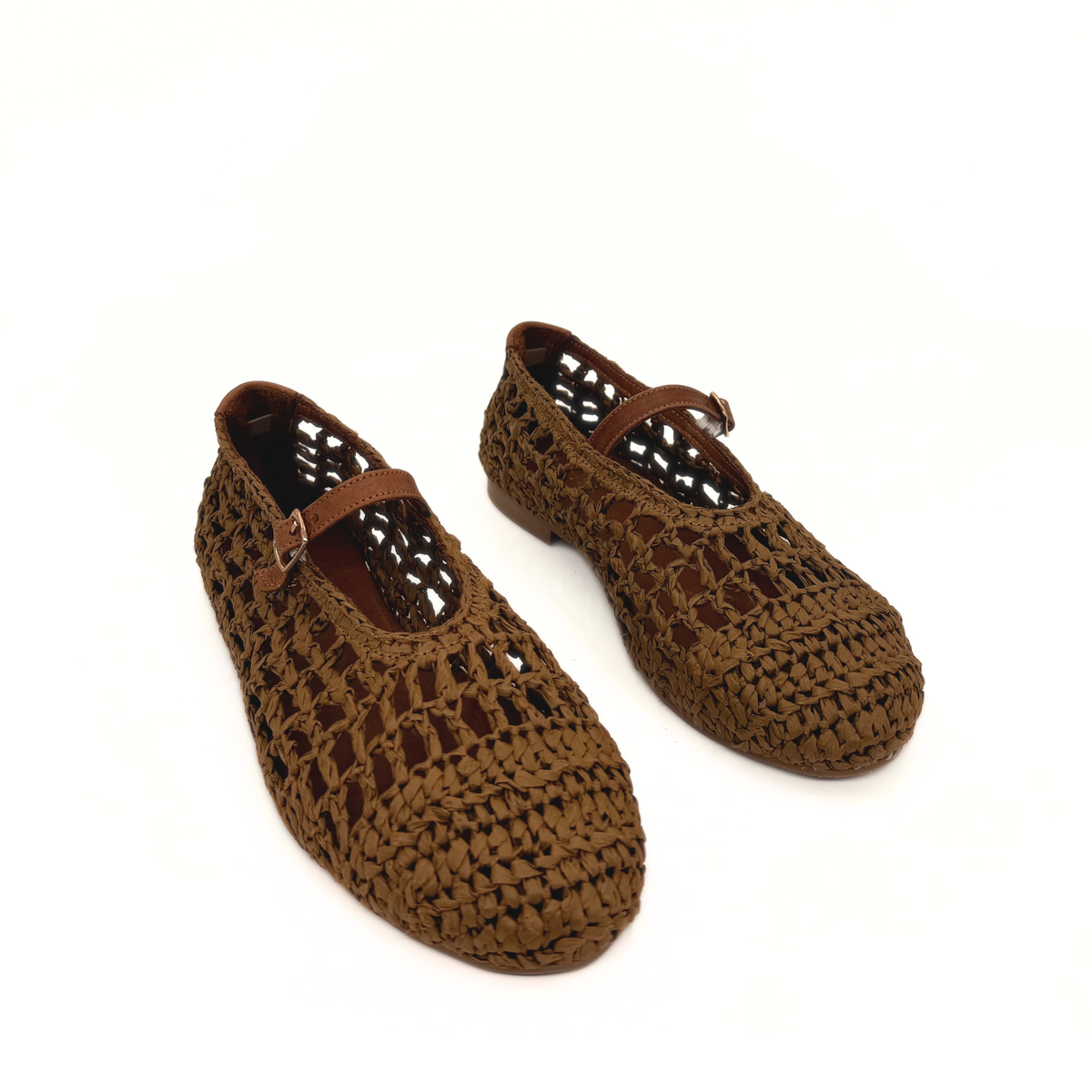 Pair of brown raffia Mary Jane flats with cutout woven pattern and ankle strap
