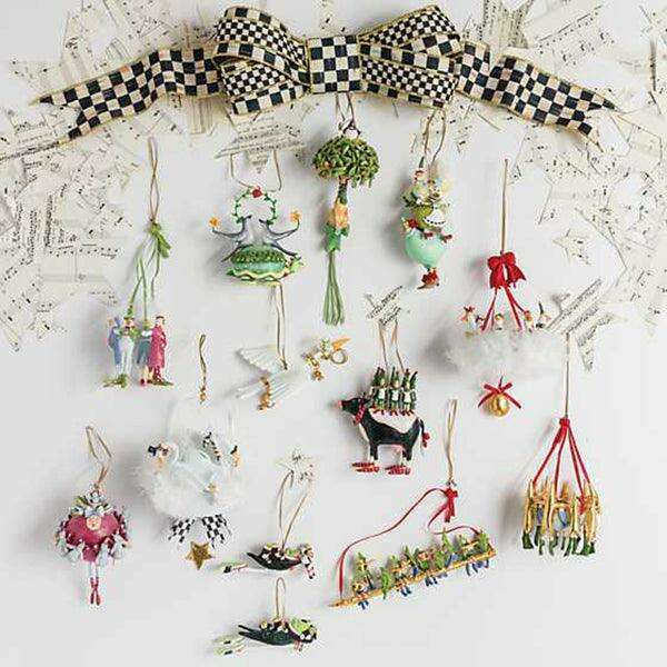 Ornament display tree with many hanging holiday figures in green, red, and gold.
