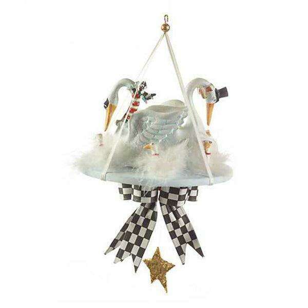 White swan ornament with raised wings, black checkered ribbon skirt, and gold star charm.