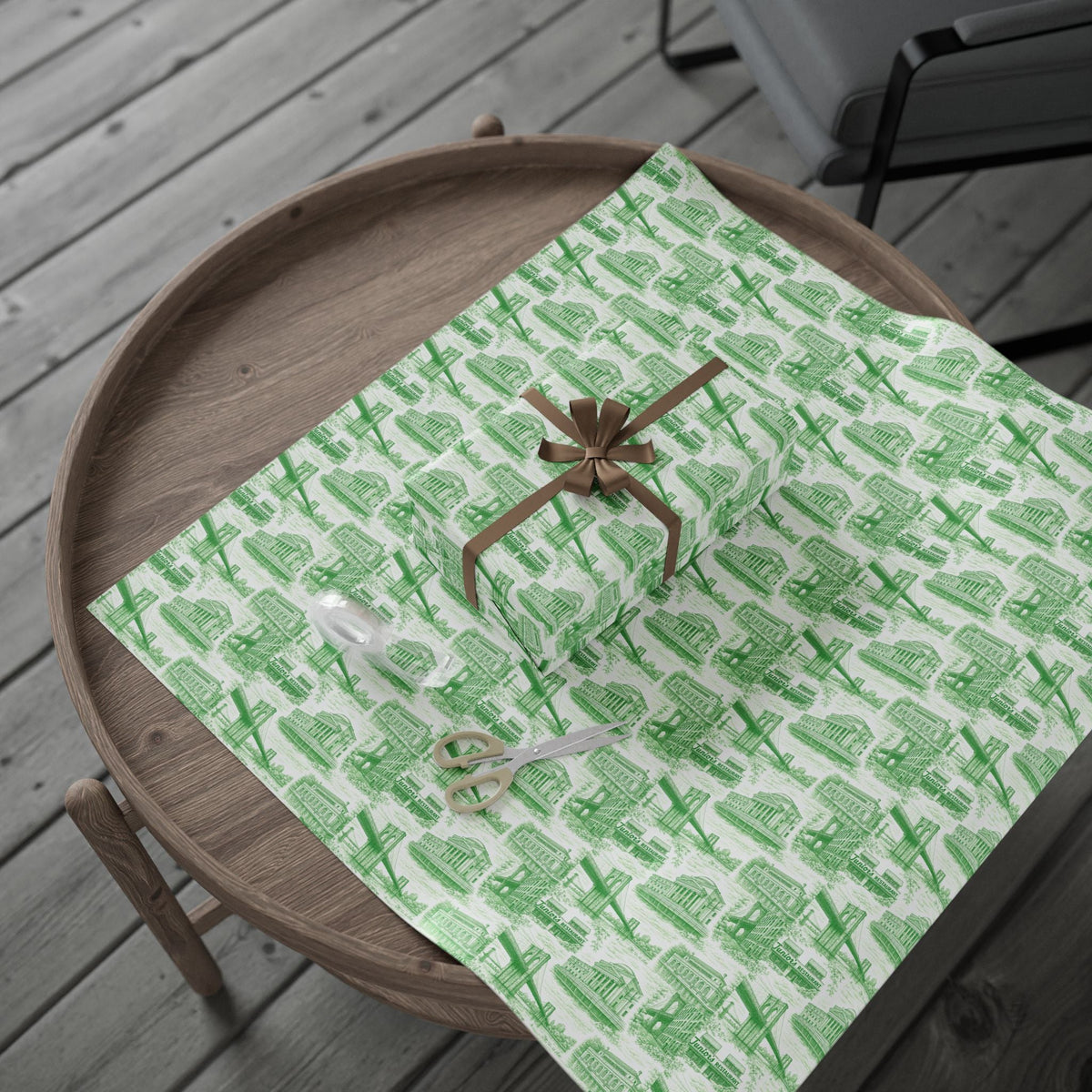 Green glossy gift wrap paper on a wooden tray, city building pattern with bow center