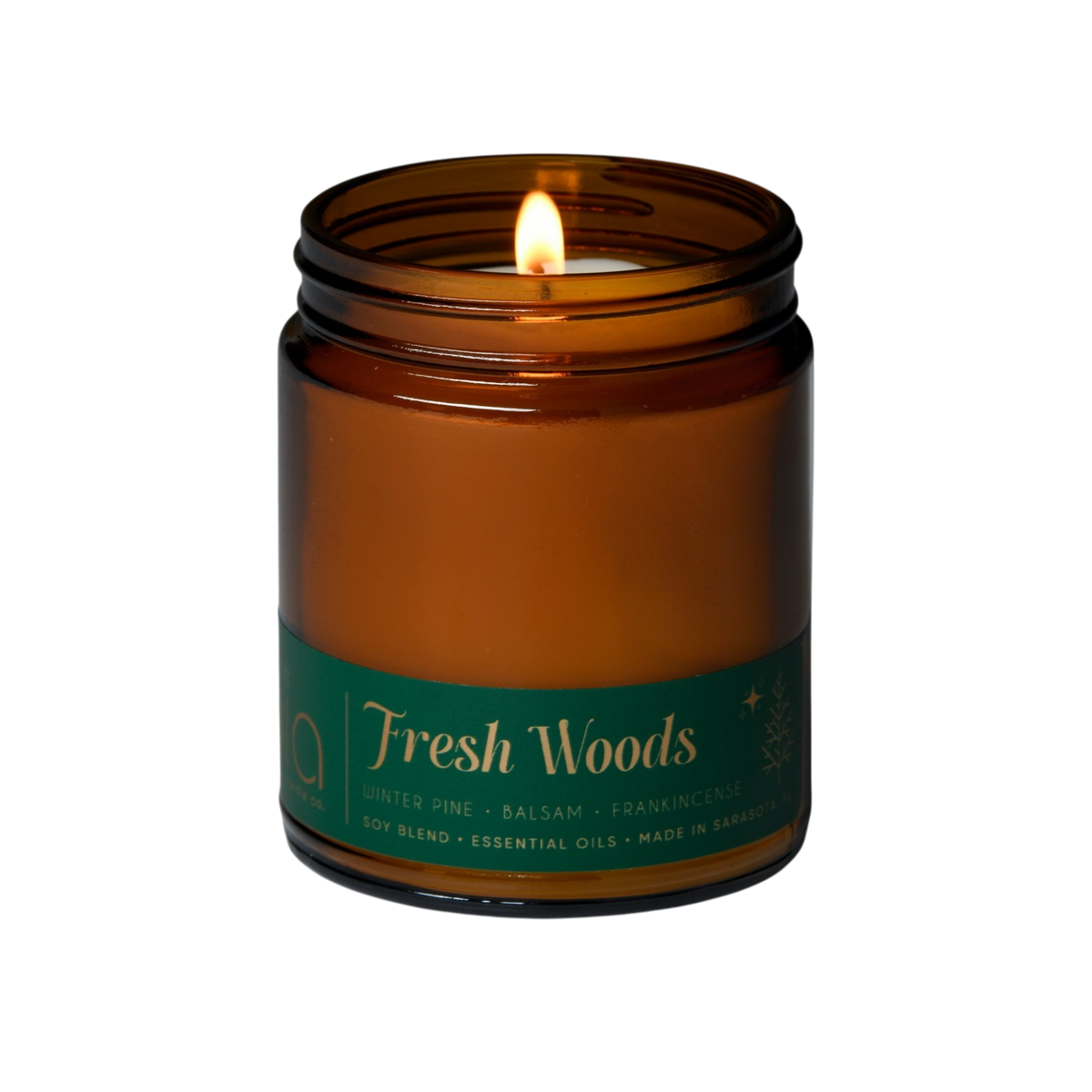 Amber soy blend candle in glass jar with lit wick and black lid