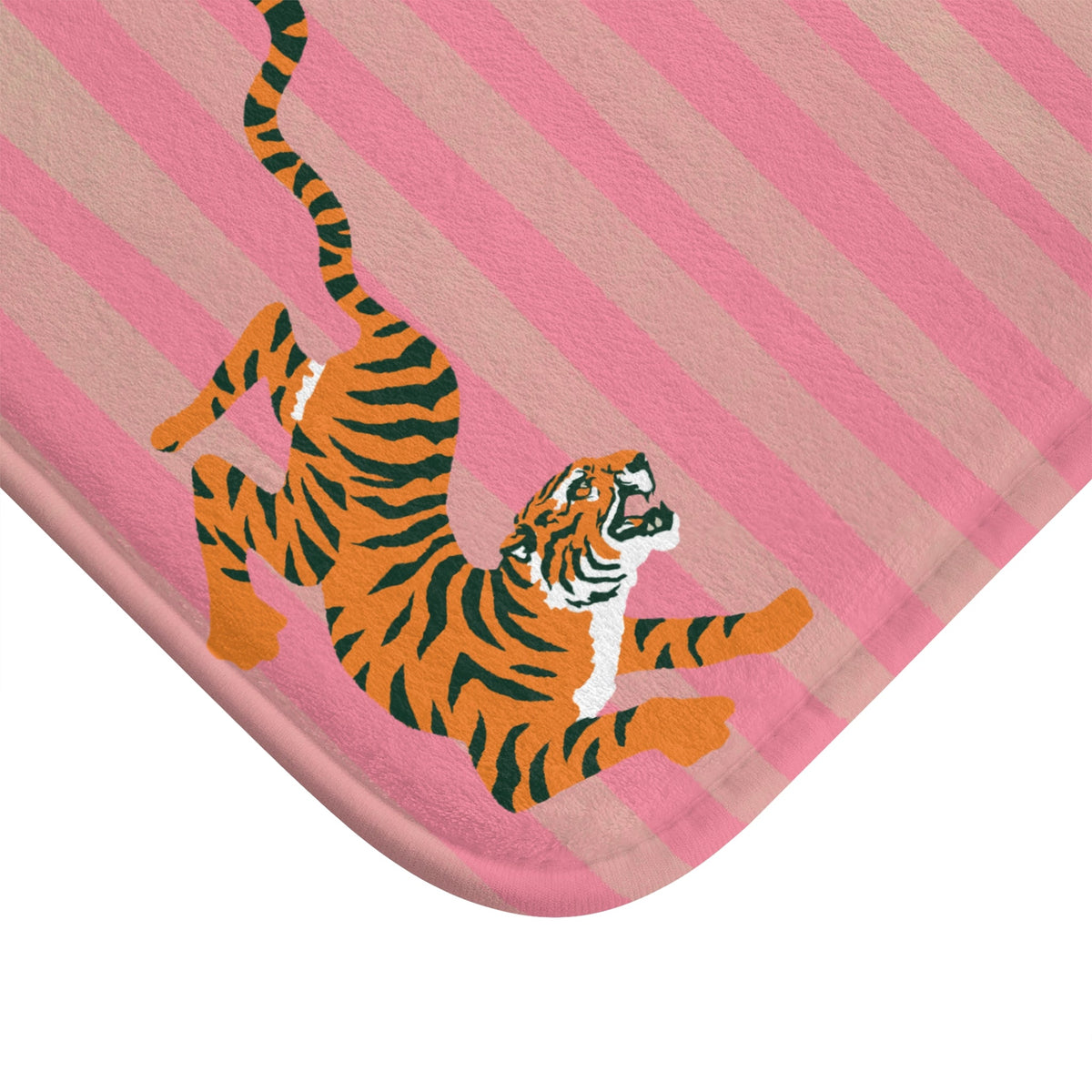 Corner detail of pink striped bath mat with orange tiger face and paws