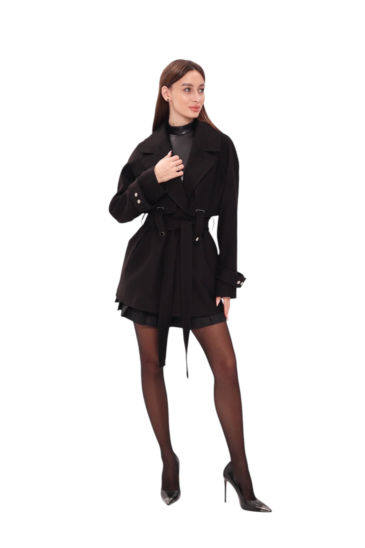 Black midi coat worn open, with wide lapels, belt, and buttoned cuffs