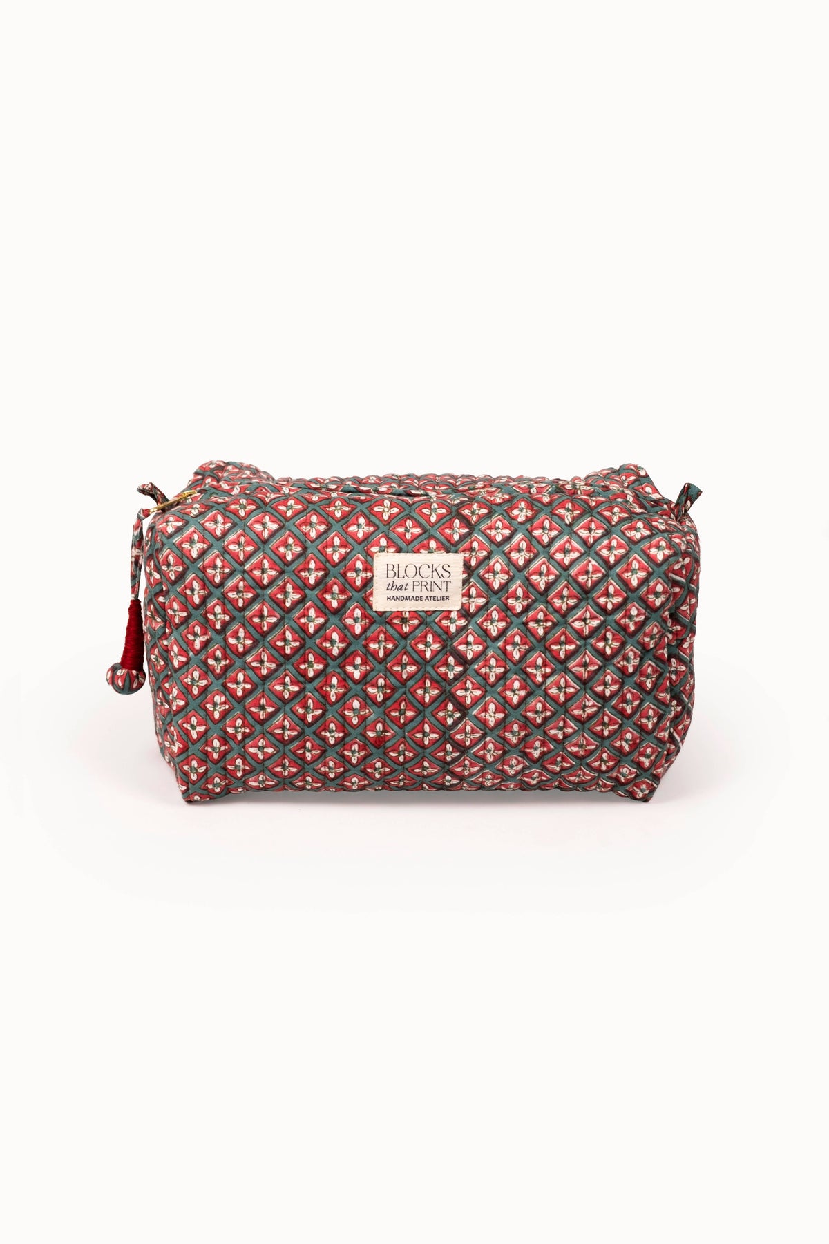Quilted travel pouch with red and multicolor block print, top zip and wrist strap