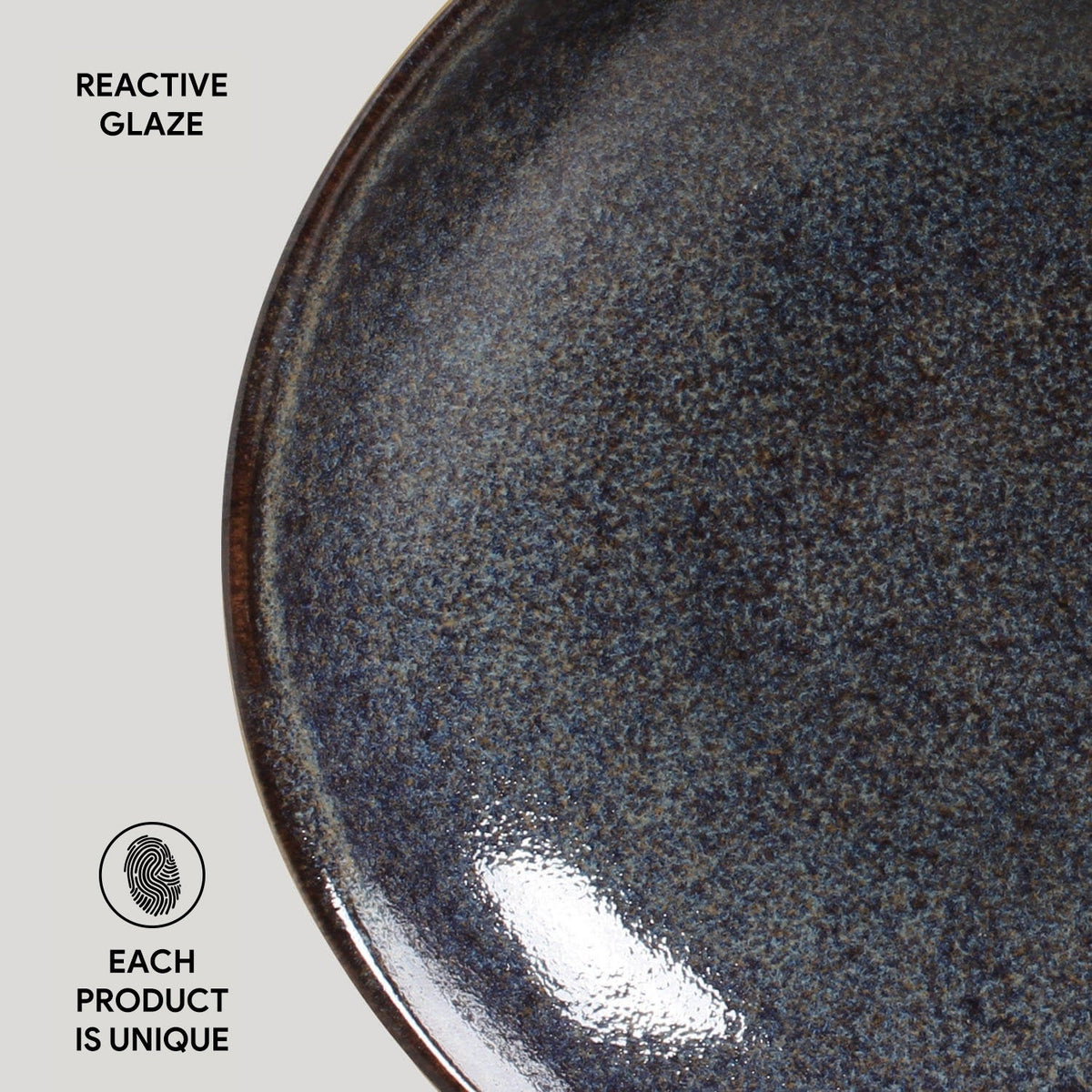 Reactive glaze pasta plate with dark blue-gray speckled finish and glossy rim.