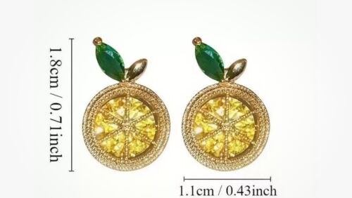 Round gold-tone stud earrings with yellow zirconia face, green leaf top, and starburst detail
