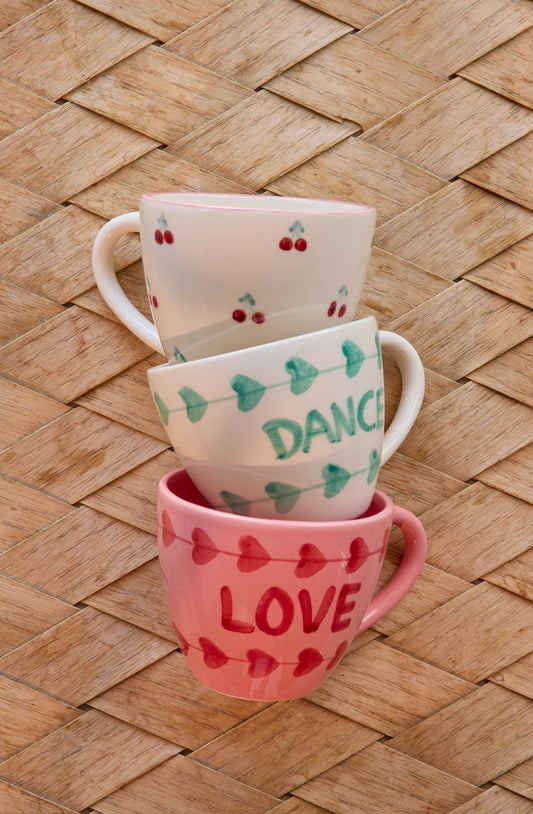 Ceramic cups set: pink LOVE cup, white DANCE cup, and green-heart cup