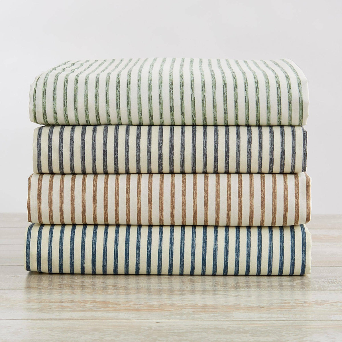 Striped microfiber sheet set with folded flat sheets in green, blue, taupe, and navy