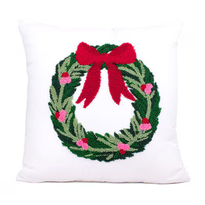 Holiday throw pillow with embroidered wreath and red bow on white cover