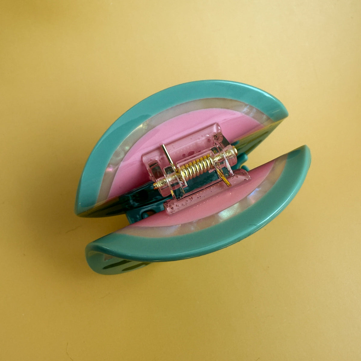 Watermelon hair claw close-up with metal spring hinge on pink slice backing