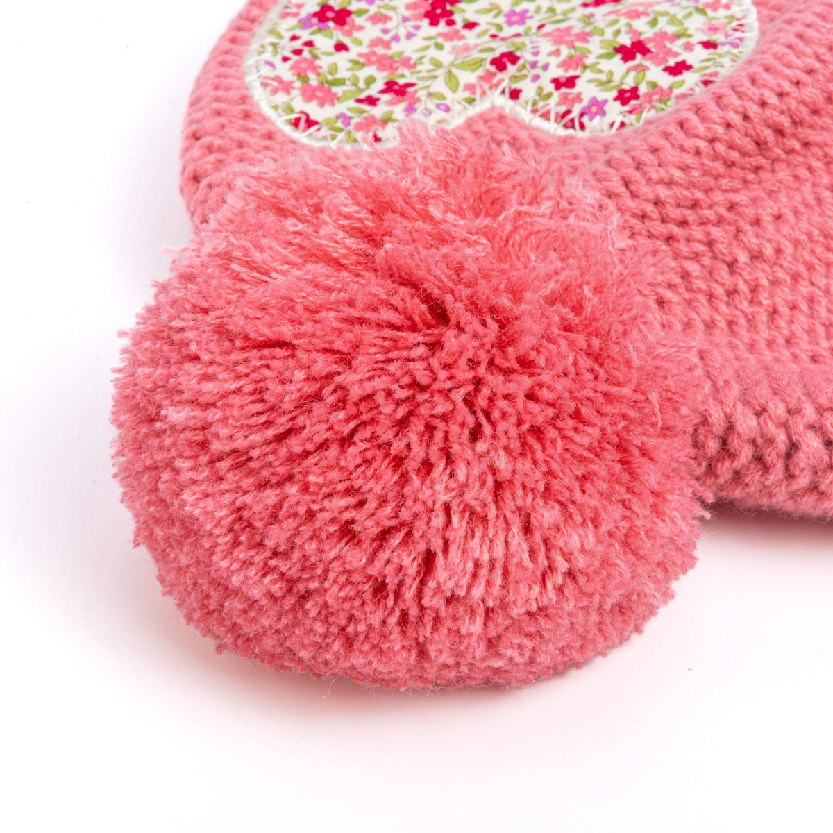 Coral pink beanie pompom with soft, fluffy yarn texture