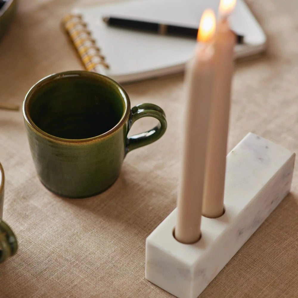 Marble candle holder with two lit pillar candles in front openings
