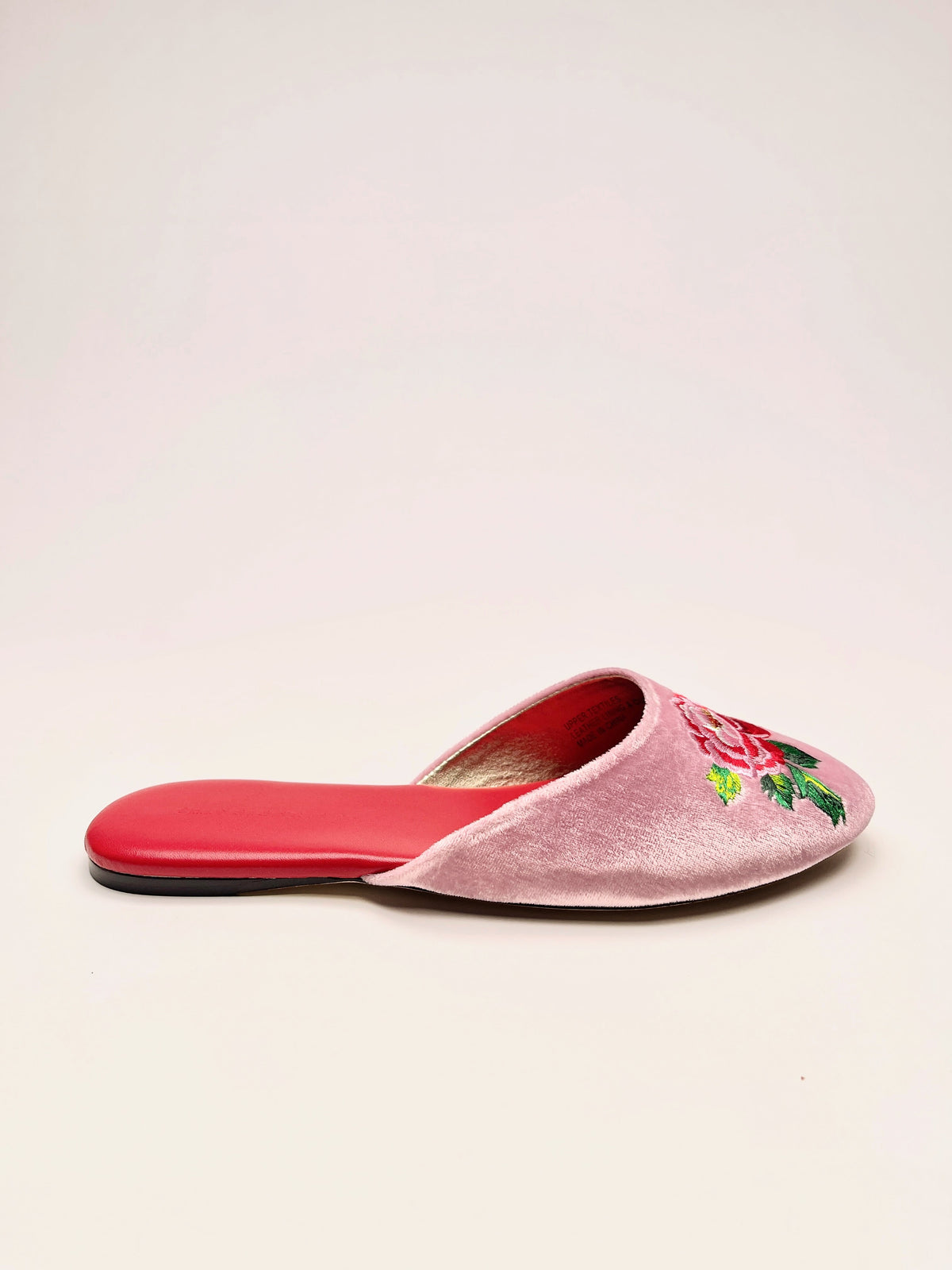 Side view of lavender pink embroidered velvet mules with peony flowers and red outsole