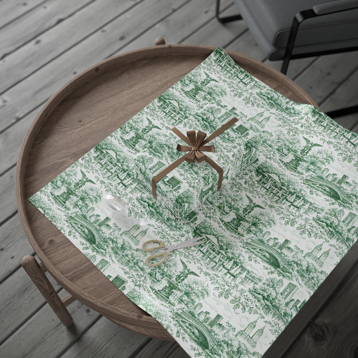 Green toile wrapping paper sheet with skyline and park scene, tied with brown bow