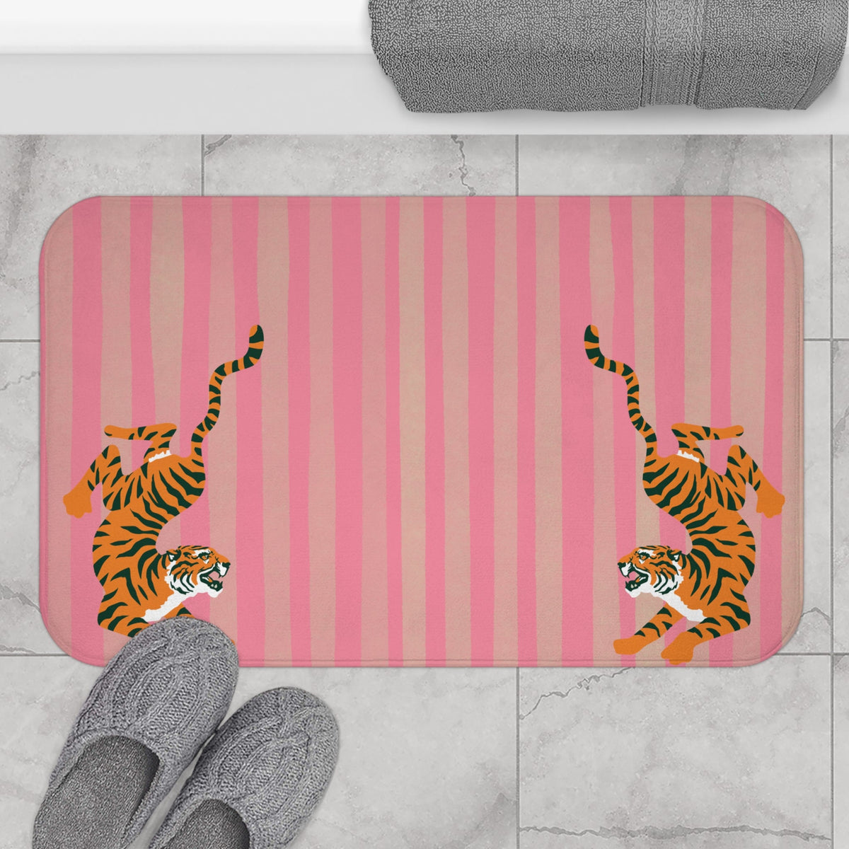 Pink striped bath mat with two tigers printed near the left and right edges