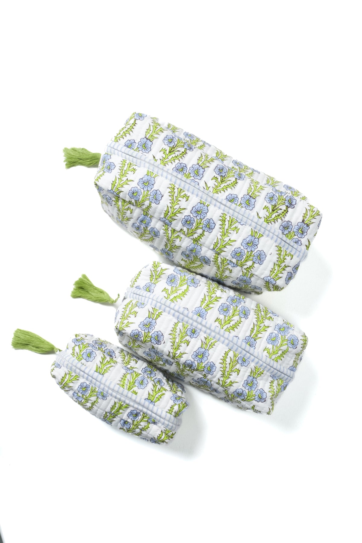 Blue floral blockprint makeup bags with zippers and green tassels, stacked view.