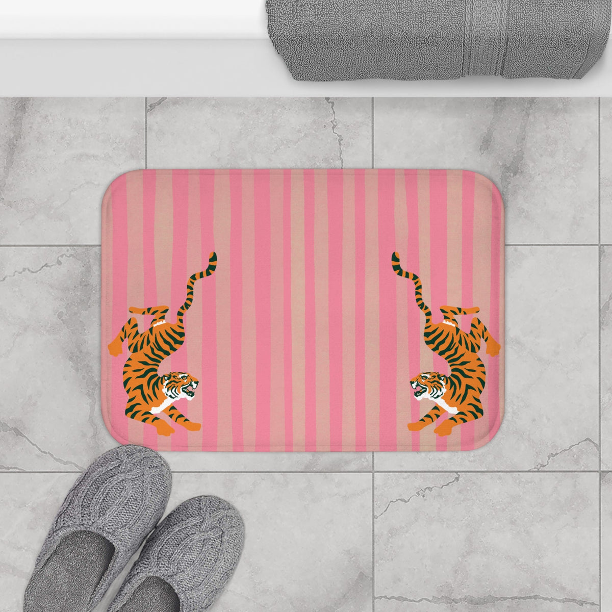 Pink striped bath mat with mirrored tiger designs and rounded edges