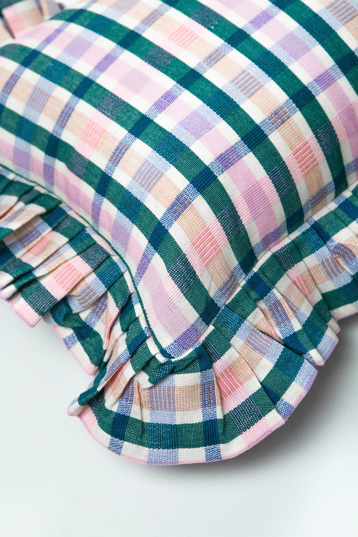Close-up of multicolor plaid pillow with ruffled trim along the edge